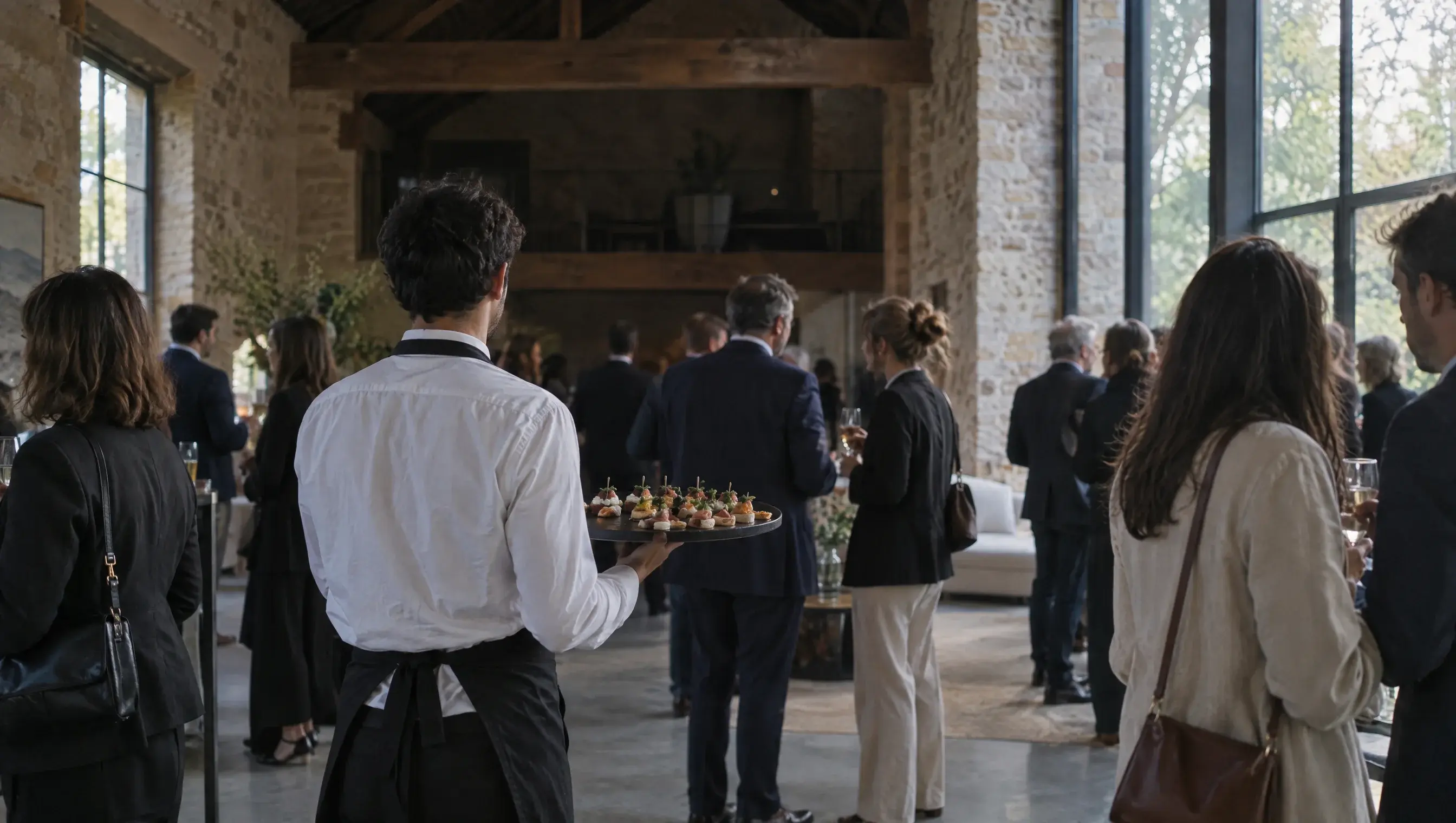 Cocktail d'entreprise : un serveur propose des bouchées aux invités